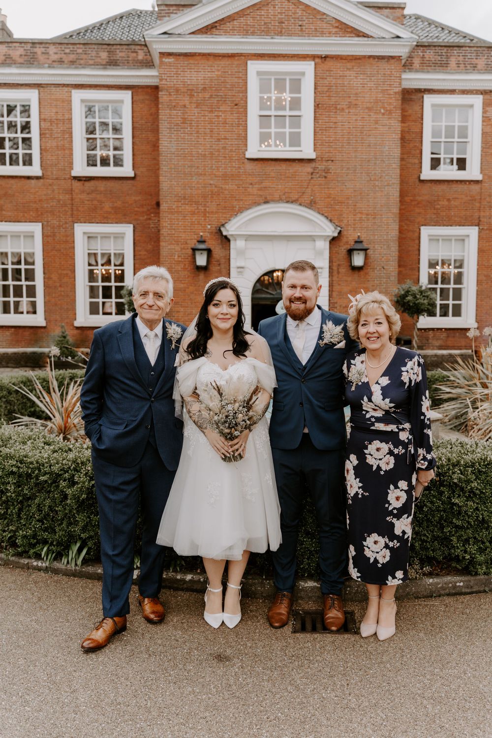 a formal portrait of a bride and groom and the brides parents.