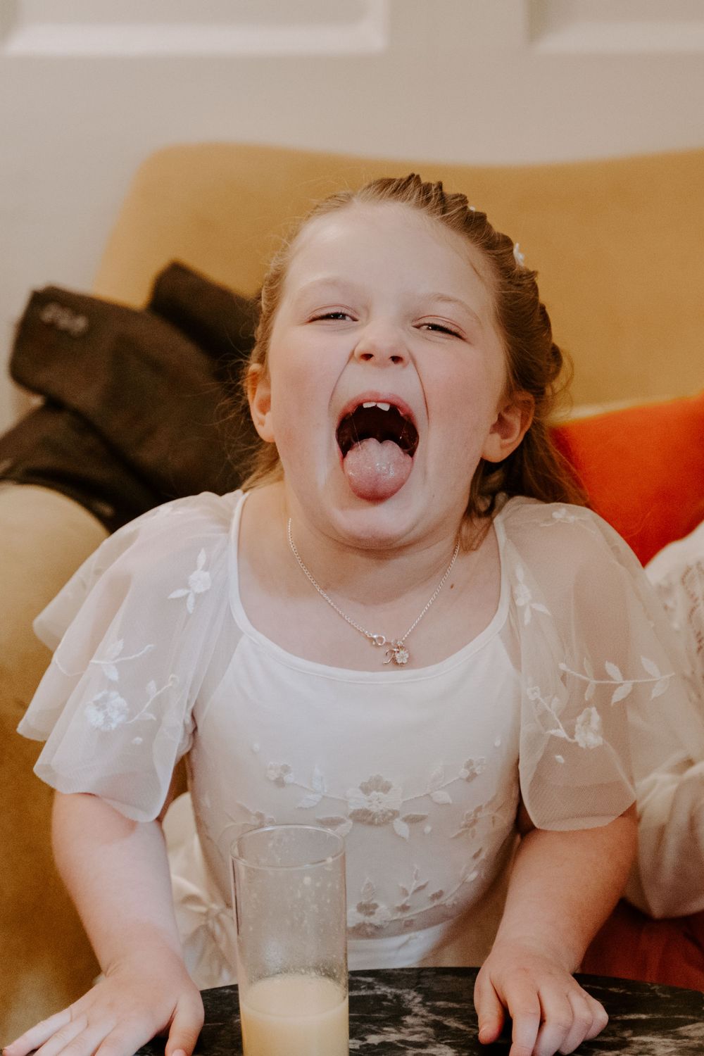 the flower girl sticking her tongue out at the camera.