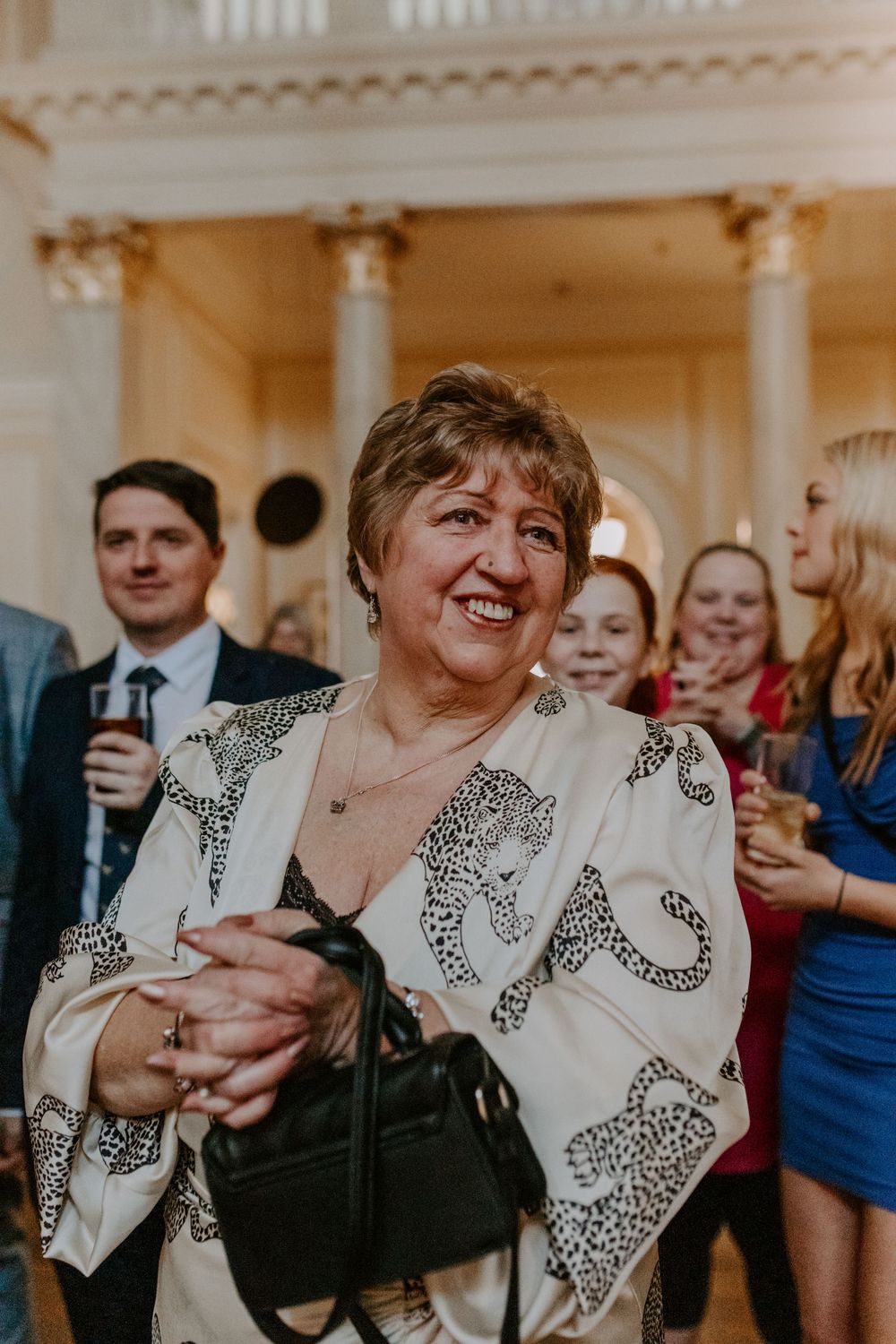 a mum of the groom smiling while listening to the wedding speeches.