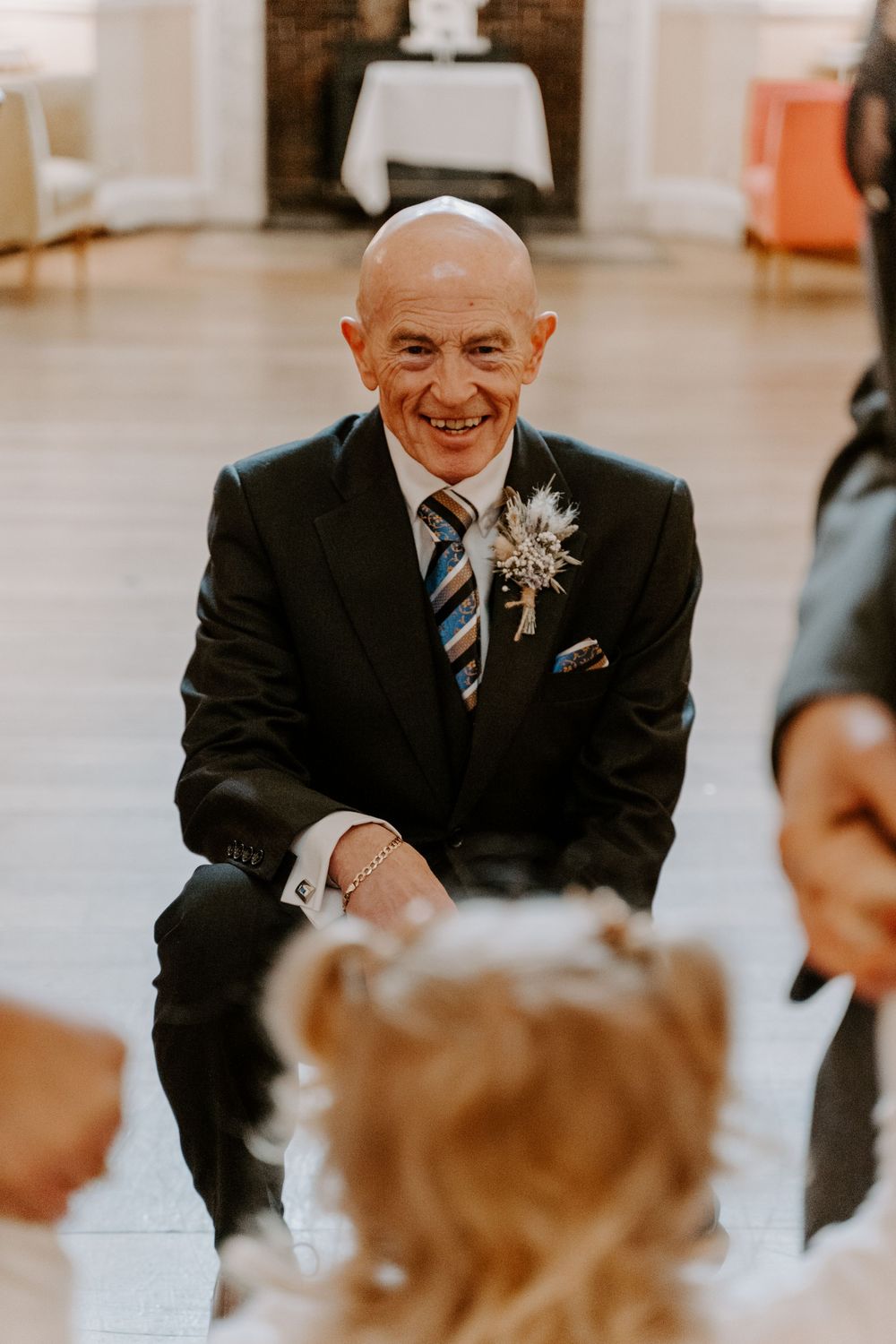 A wedding guest laughing and talking to a child.
