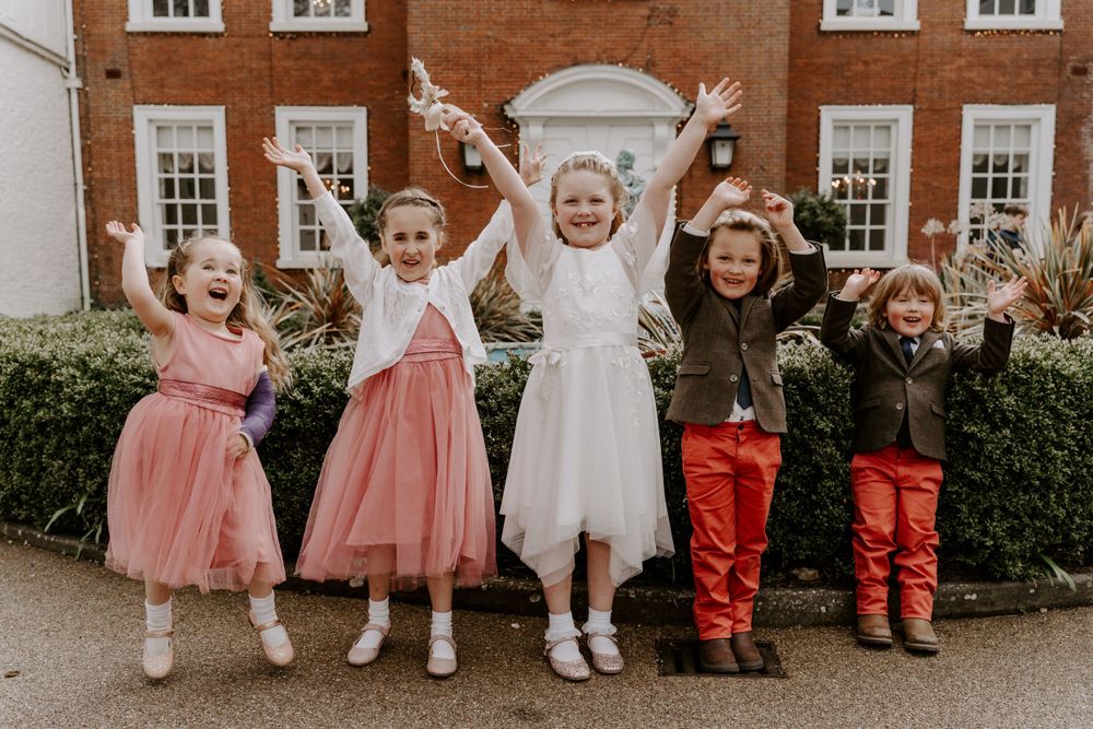 A group of children throwing their arms in the air and laughing.
