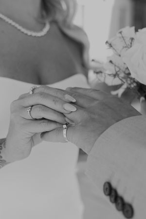 Black and white detail shot of wedding ring exchange during ceremony.