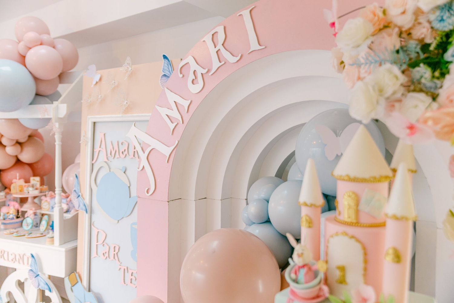 Pink and pastel party decorations with balloons and floral accents create a dreamy celebration atmosphere.