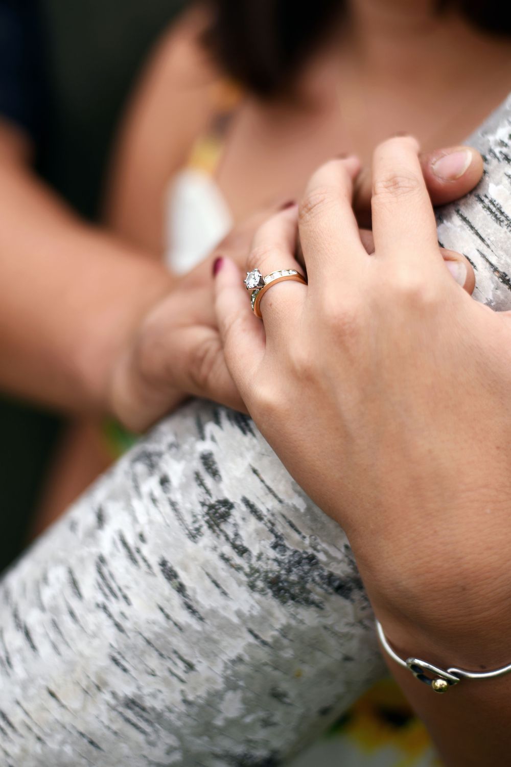 Close-up of a diamond engagement ring on a woman's hand during an outdoor engagement session