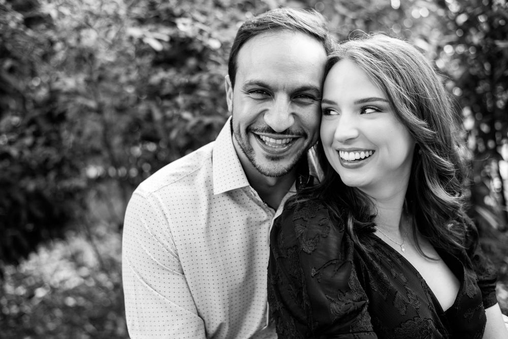 Black-and-white engagement portrait of a smiling couple cuddling together outdoors in Providence, Rhode Island
