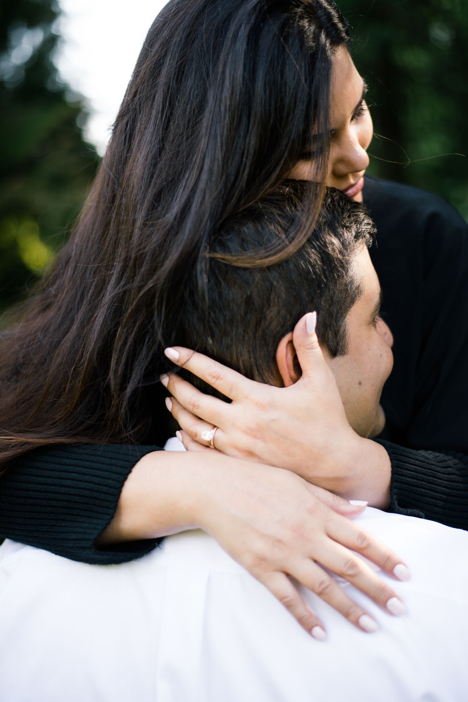 An intimate embrace showcasing an engagement ring during a romantic photoshoot.