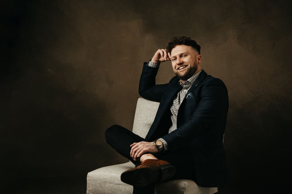 Studio portraits featuring casual poses in professional attire against dark backdrop.