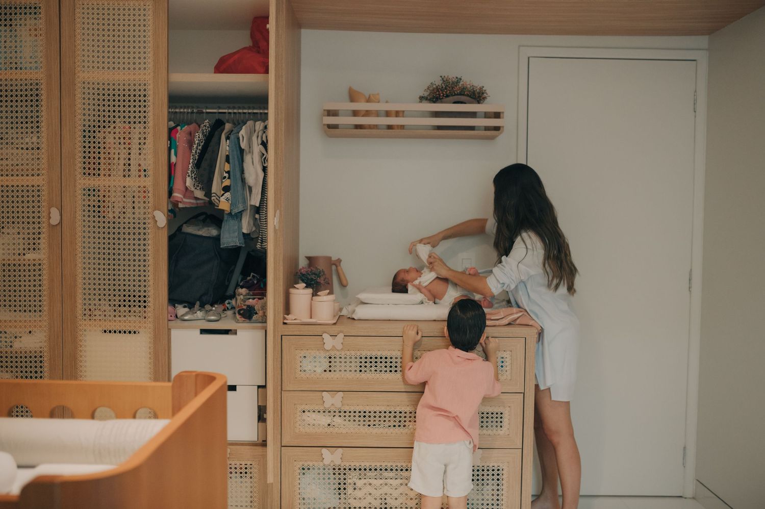 Organizing a nursery closet with storage solutions and clothing.