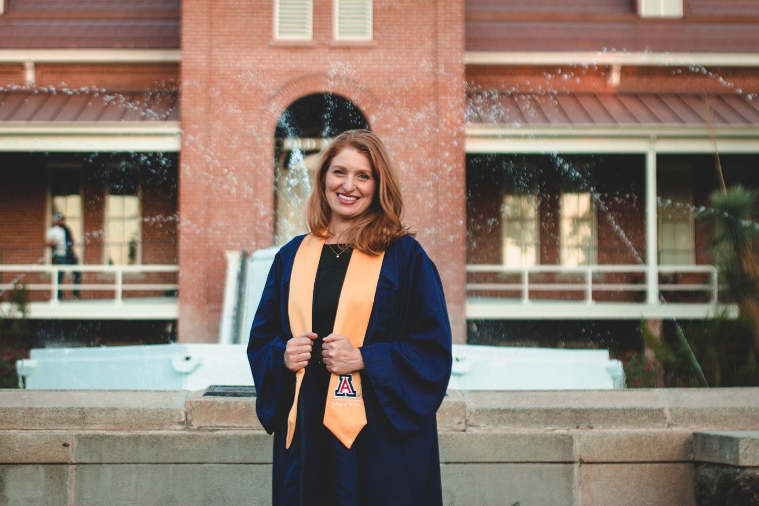 Professional graduation photos taken outside a classic brick university building.