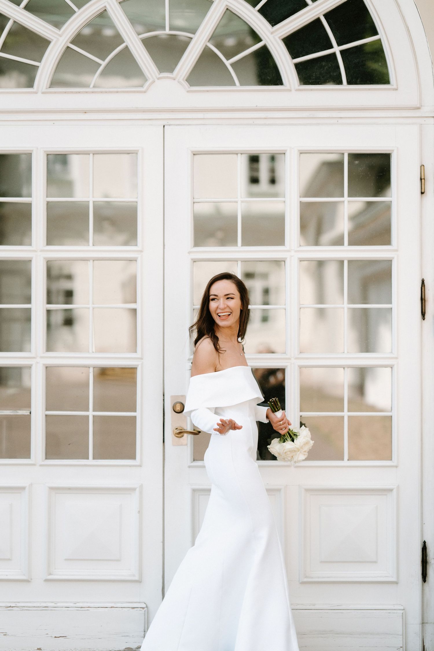 Elegant white French doors and windows create bright architectural backdrop for wedding photography.