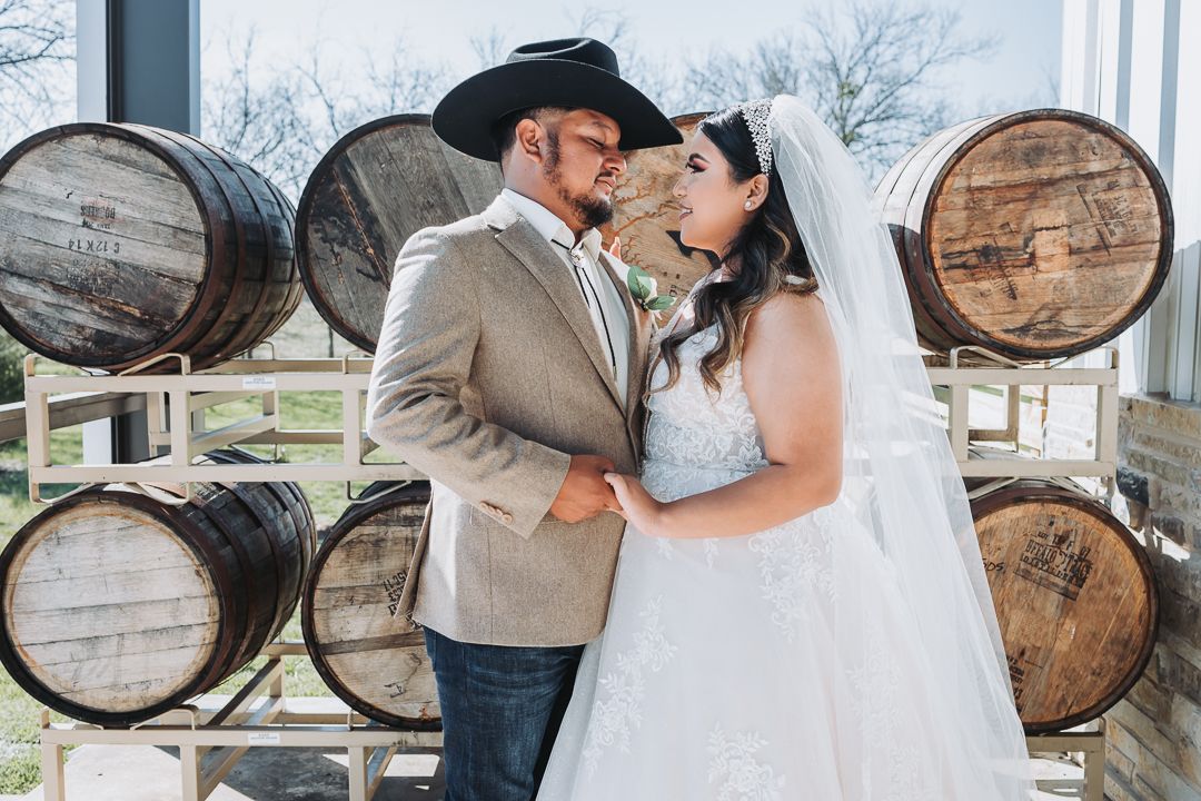 Groom holding his bride for a photographer at Caddo Creek