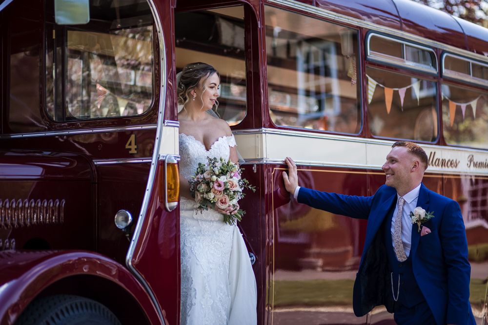 Classic maroon vintage bus provides elegant backdrop for wedding photos at Kelham House
