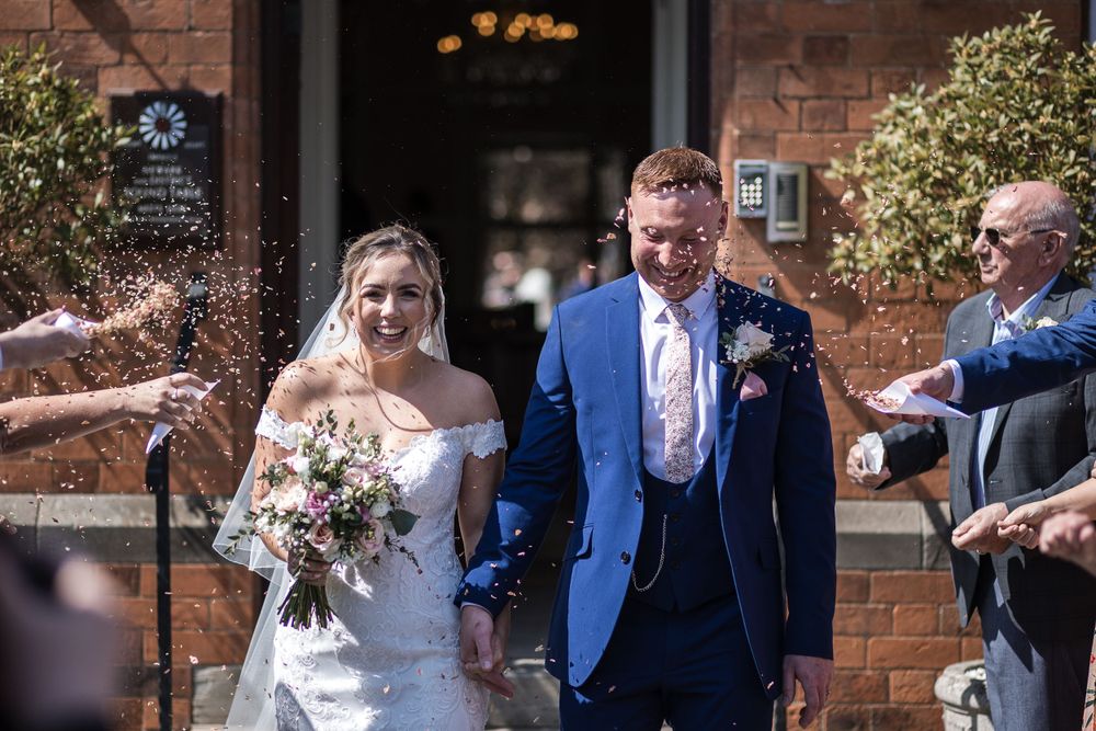 Newlyweds celebrate with friends and confetti at Kelham House