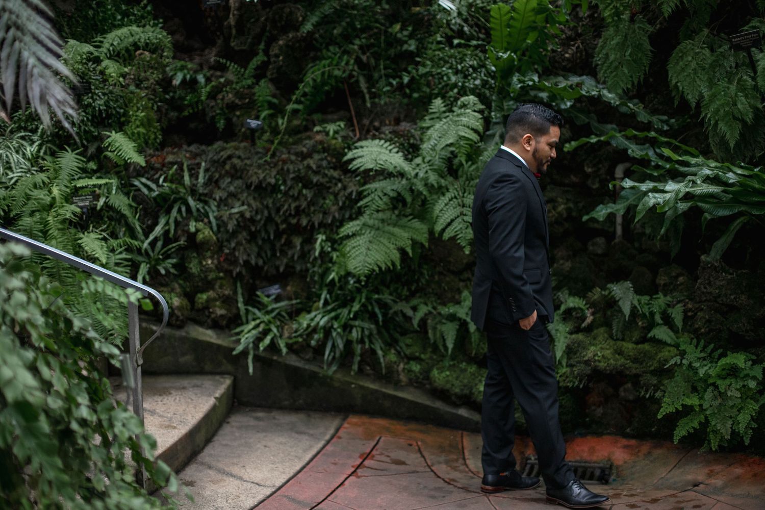 A contemplative moment captured in a lush garden walkway.