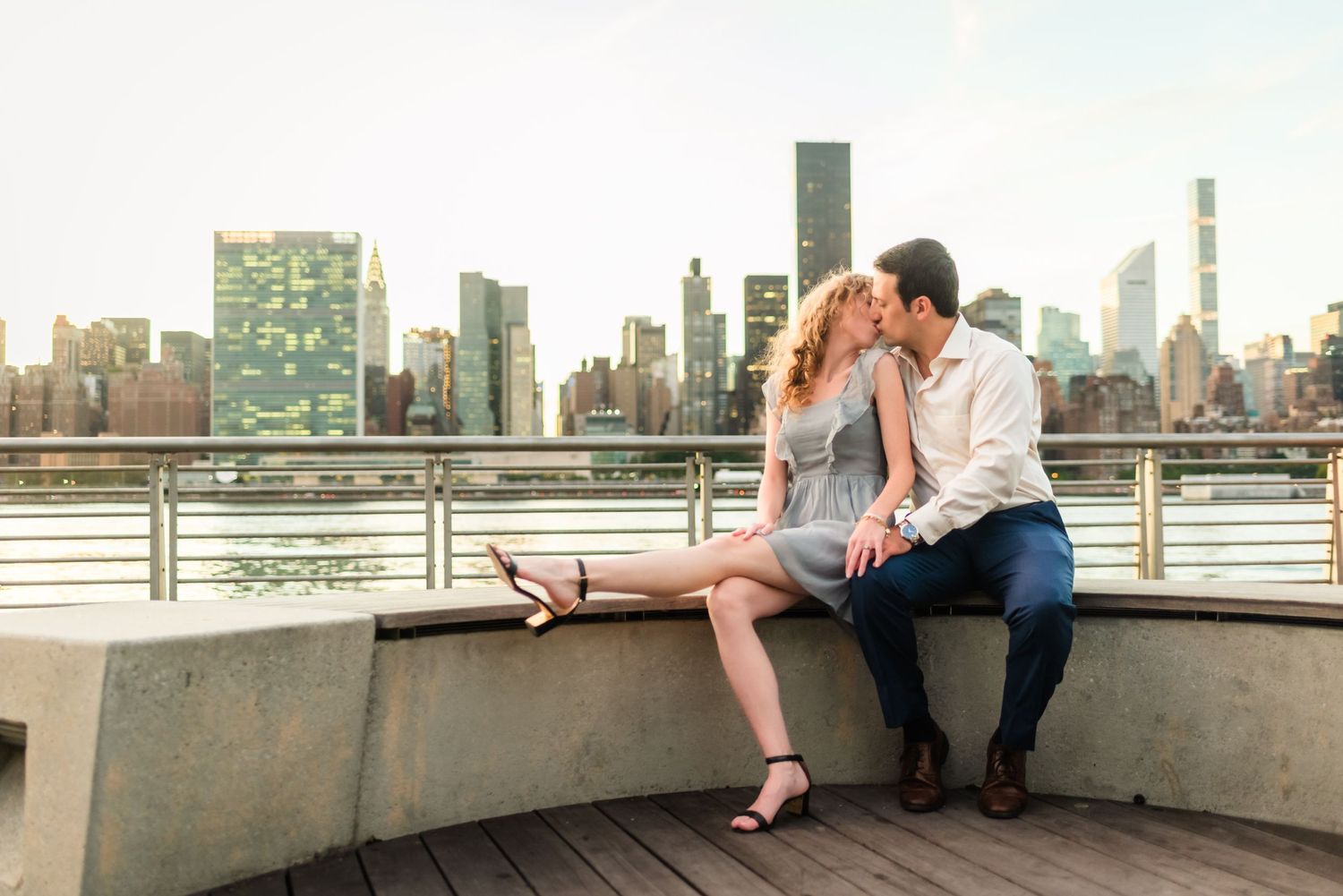 Romantic waterfront moment with Manhattan skyline visible in background.