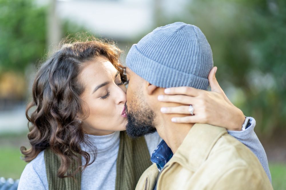A tender moment shared between a couple outdoors on a fall day.