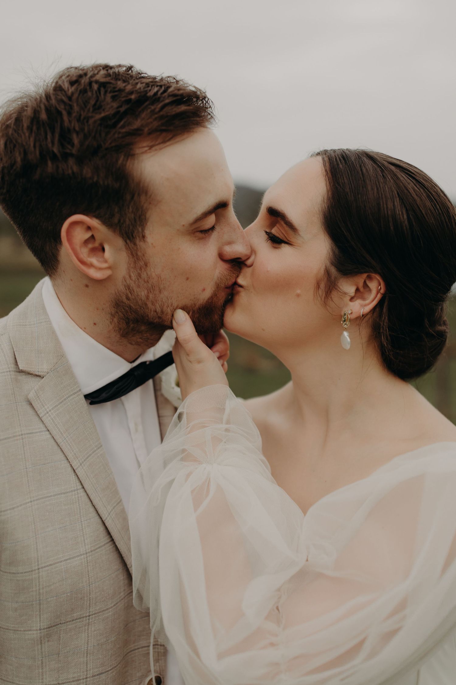 Romantic wedding couple sharing intimate moments in soft lighting.