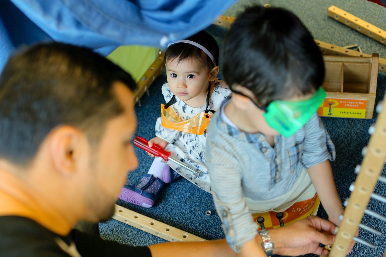 Children engaged in creative activities with building blocks in a classroom setting.