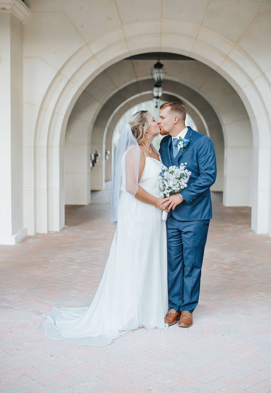 Bride and groom share intimate moments under elegant white archways in a classic wedding photoshoot.