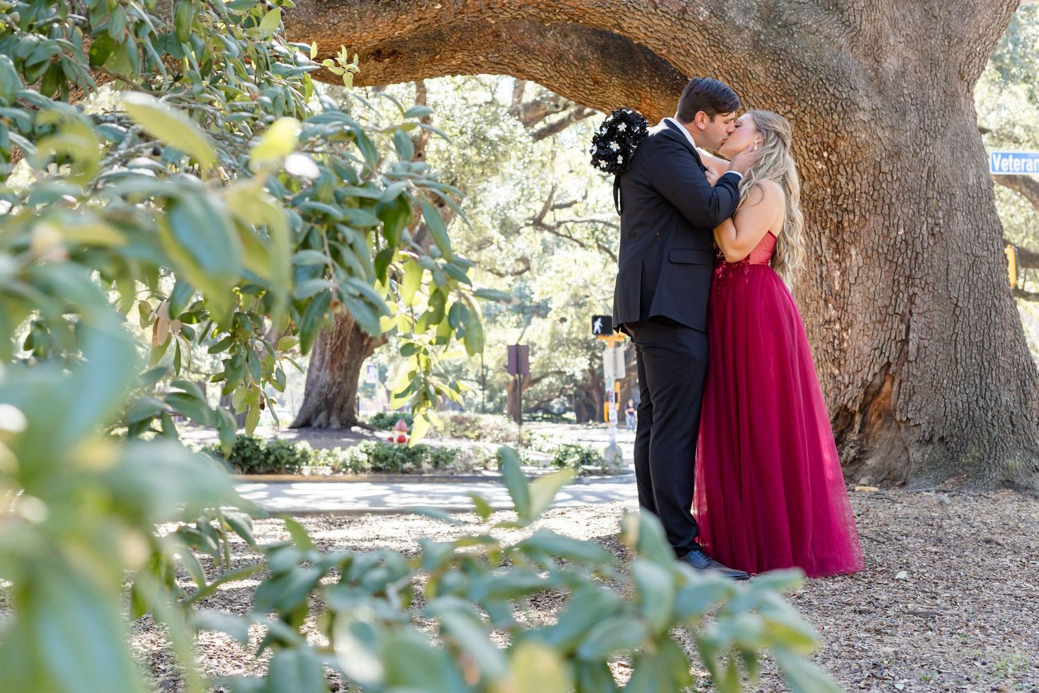 bride and groom kiss under oak tree at union square at LSU in Baton Rouge
