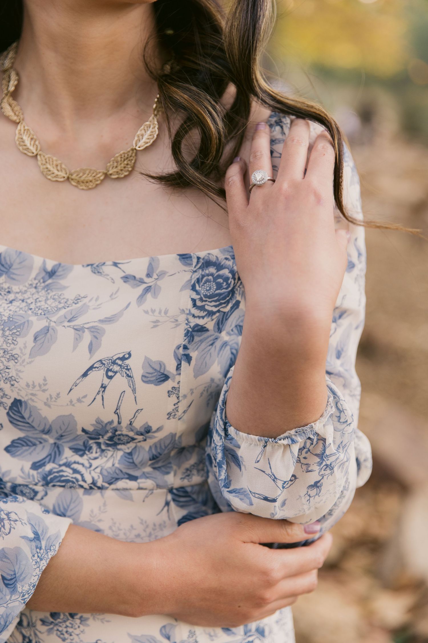 Detail shots of a delicate blue and white floral dress with gold jewelry accents.