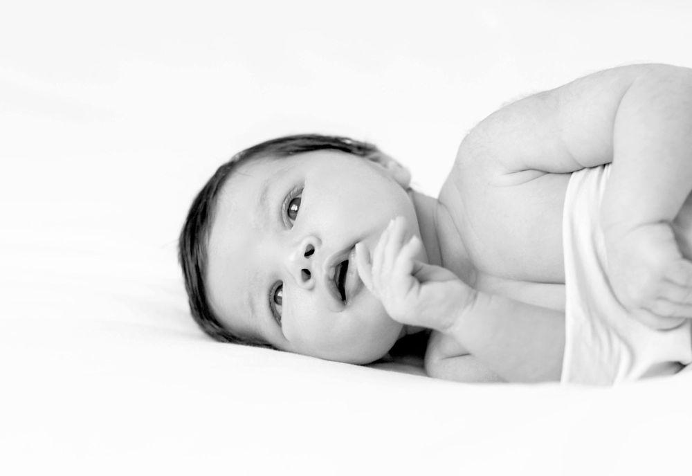 Black and white image of a newborn baby eyes wide open.