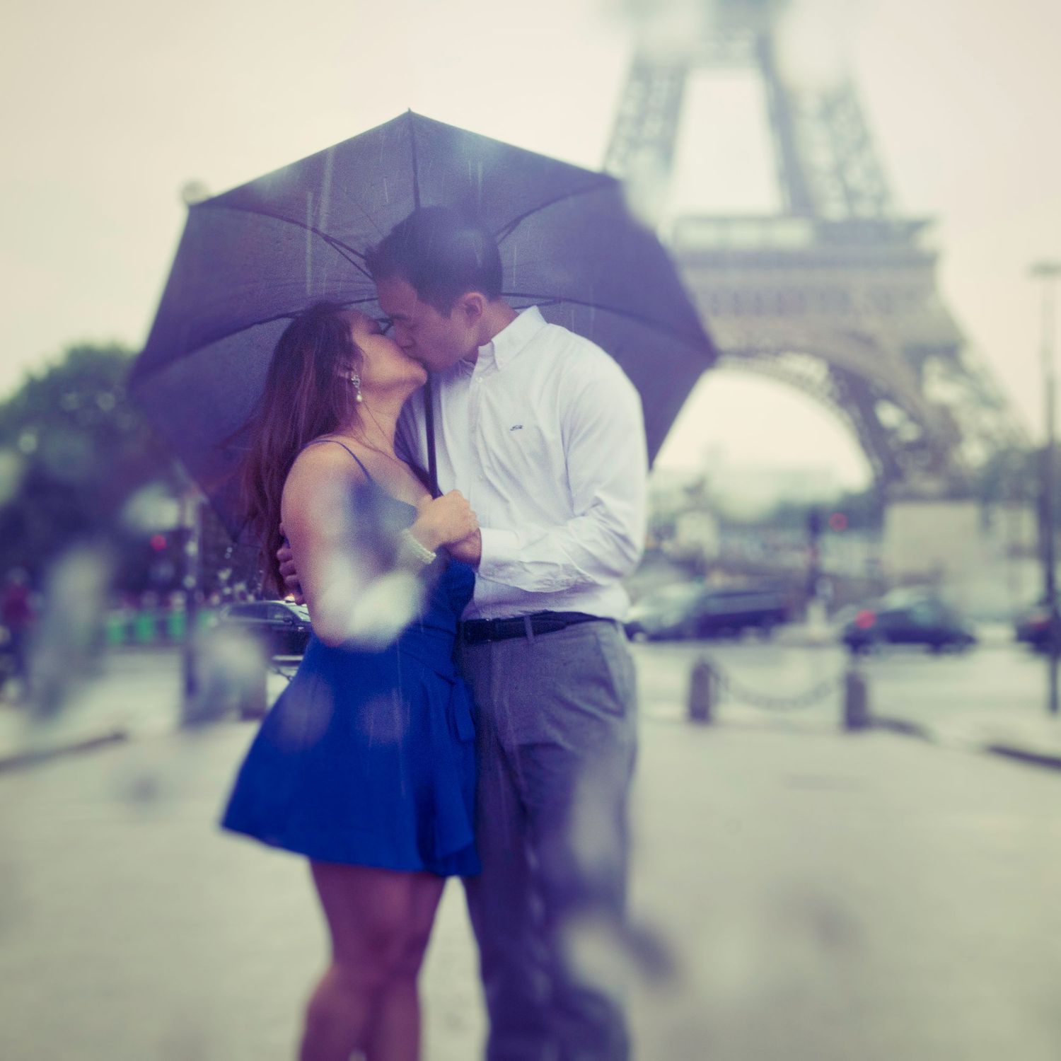 Couple kissing in the rain in front of Eiffel Tower