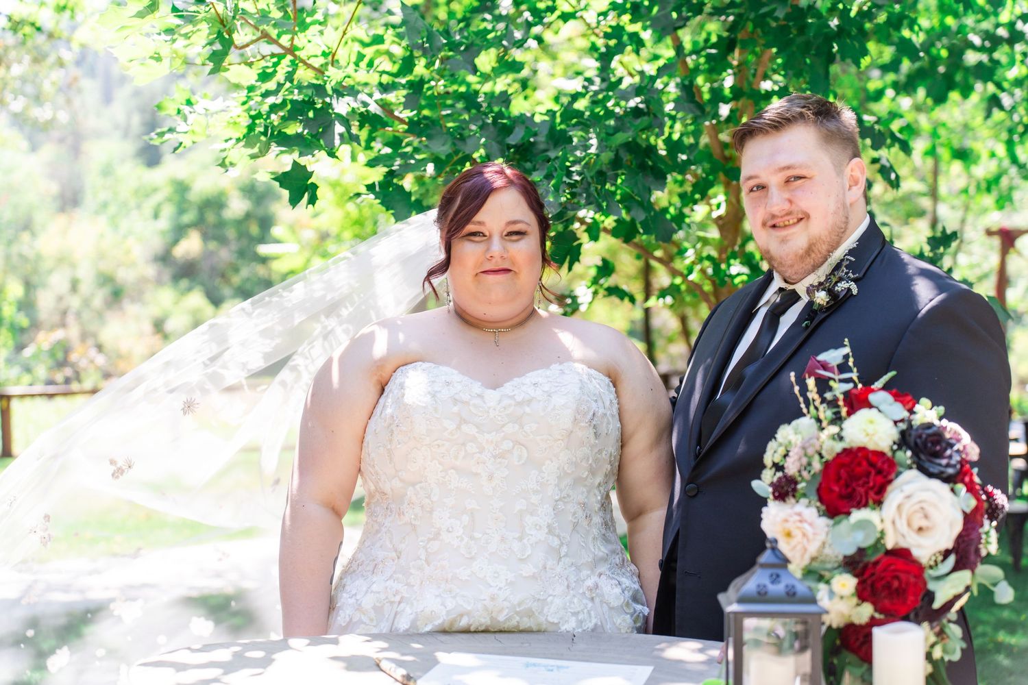 bride and groom stand by flowers