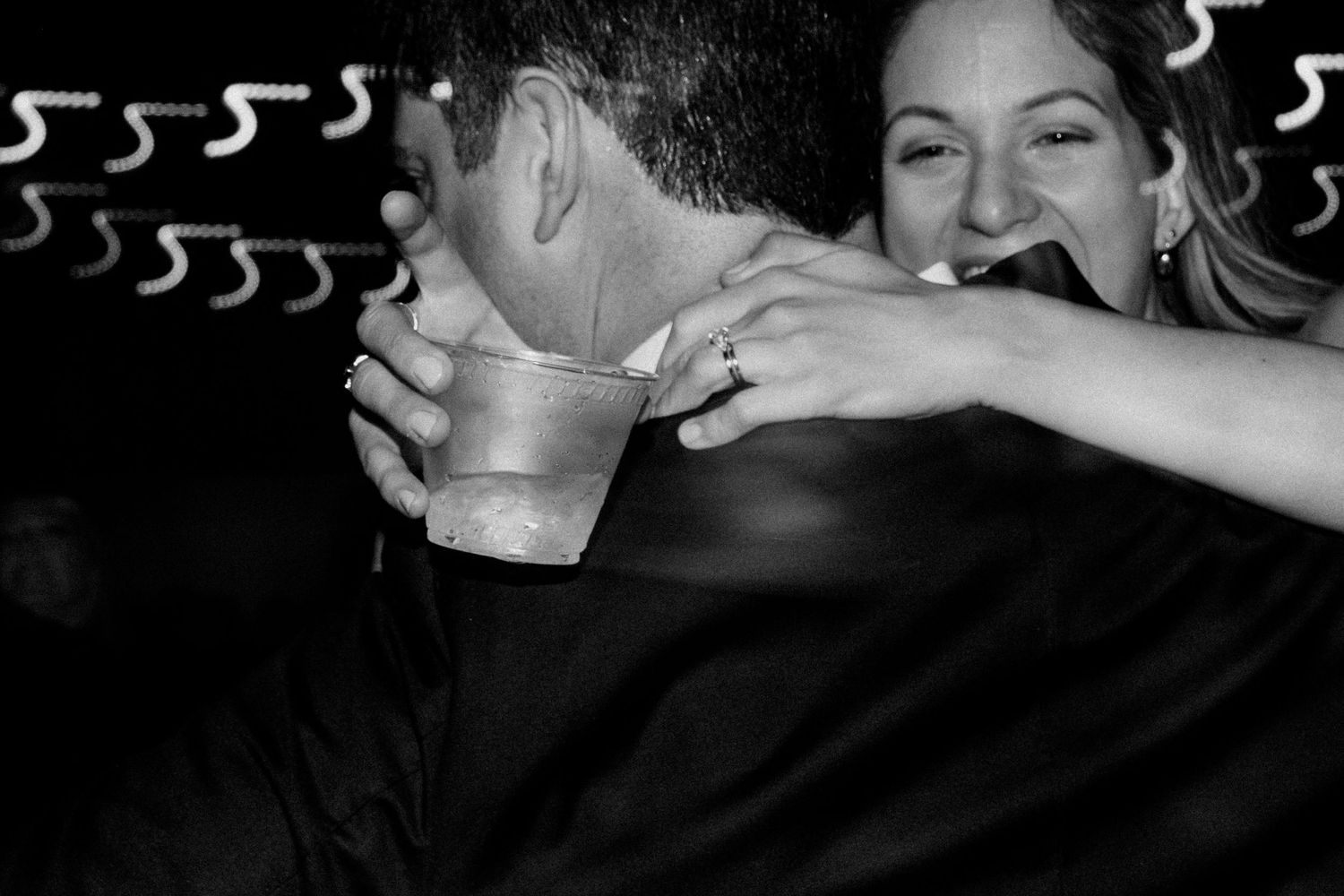 A black and white photo captures guests dancing and having drinks at a party.