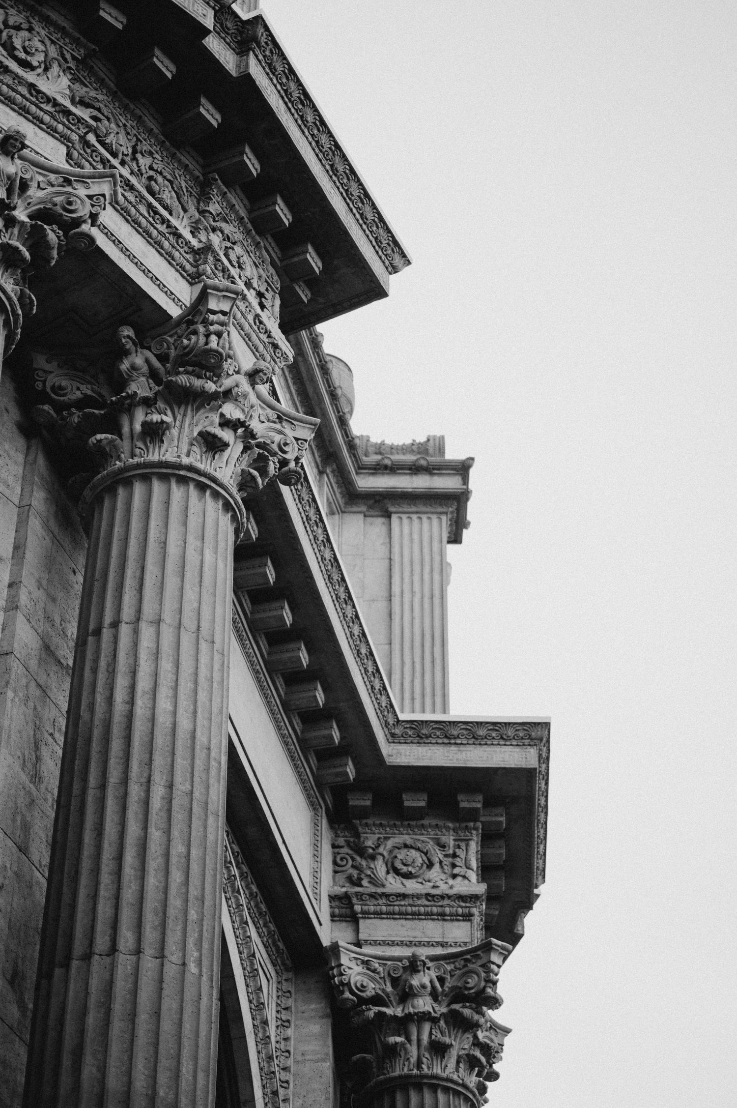 Classic architectural details of ornate Corinthian columns and decorative moldings shown in black and white.