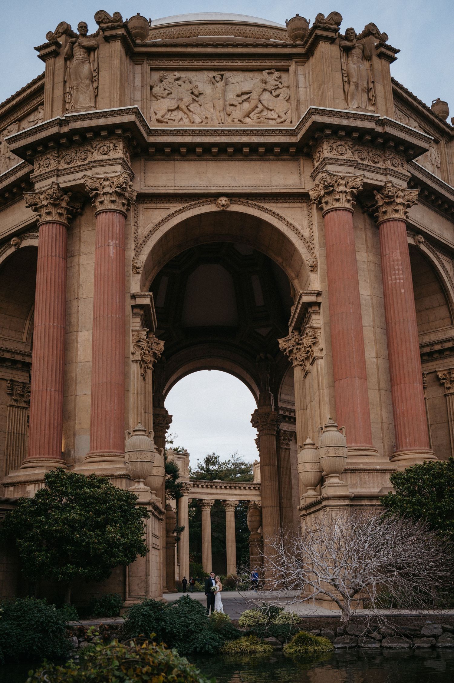Romantic wedding photo beneath the ornate Palace of Fine Arts dome in San Francisco.