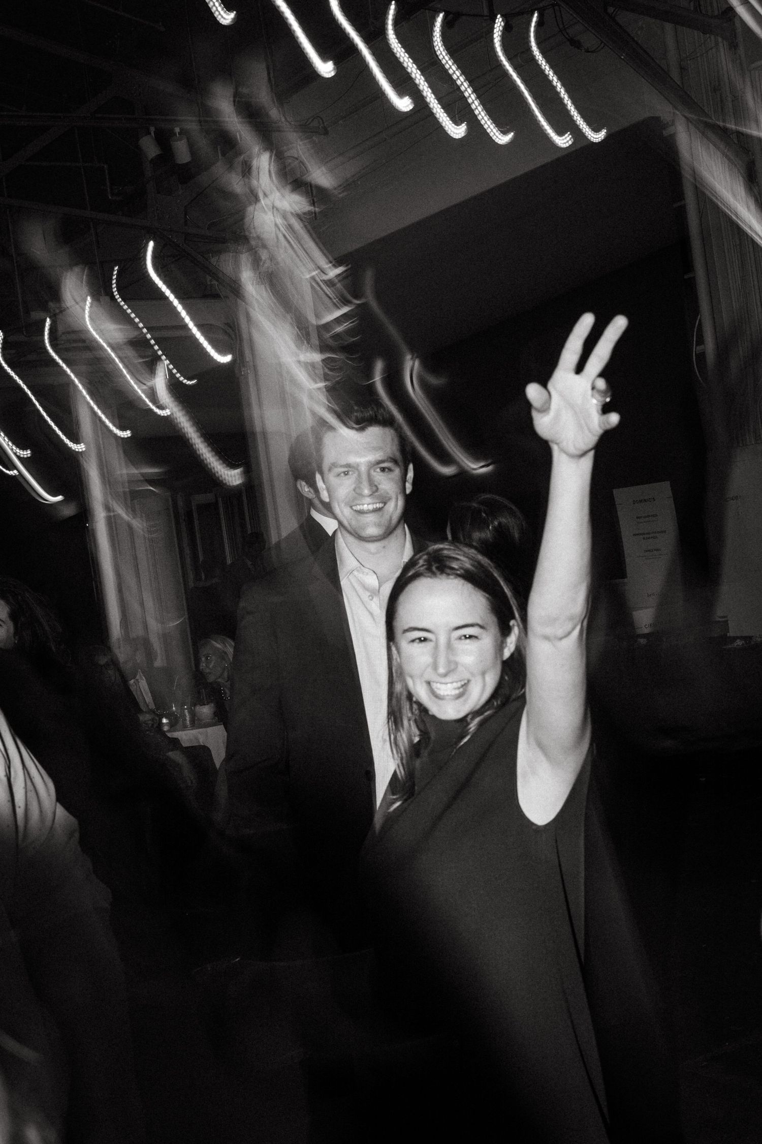 Partygoers dance under dramatic lighting effects at a nighttime celebration.