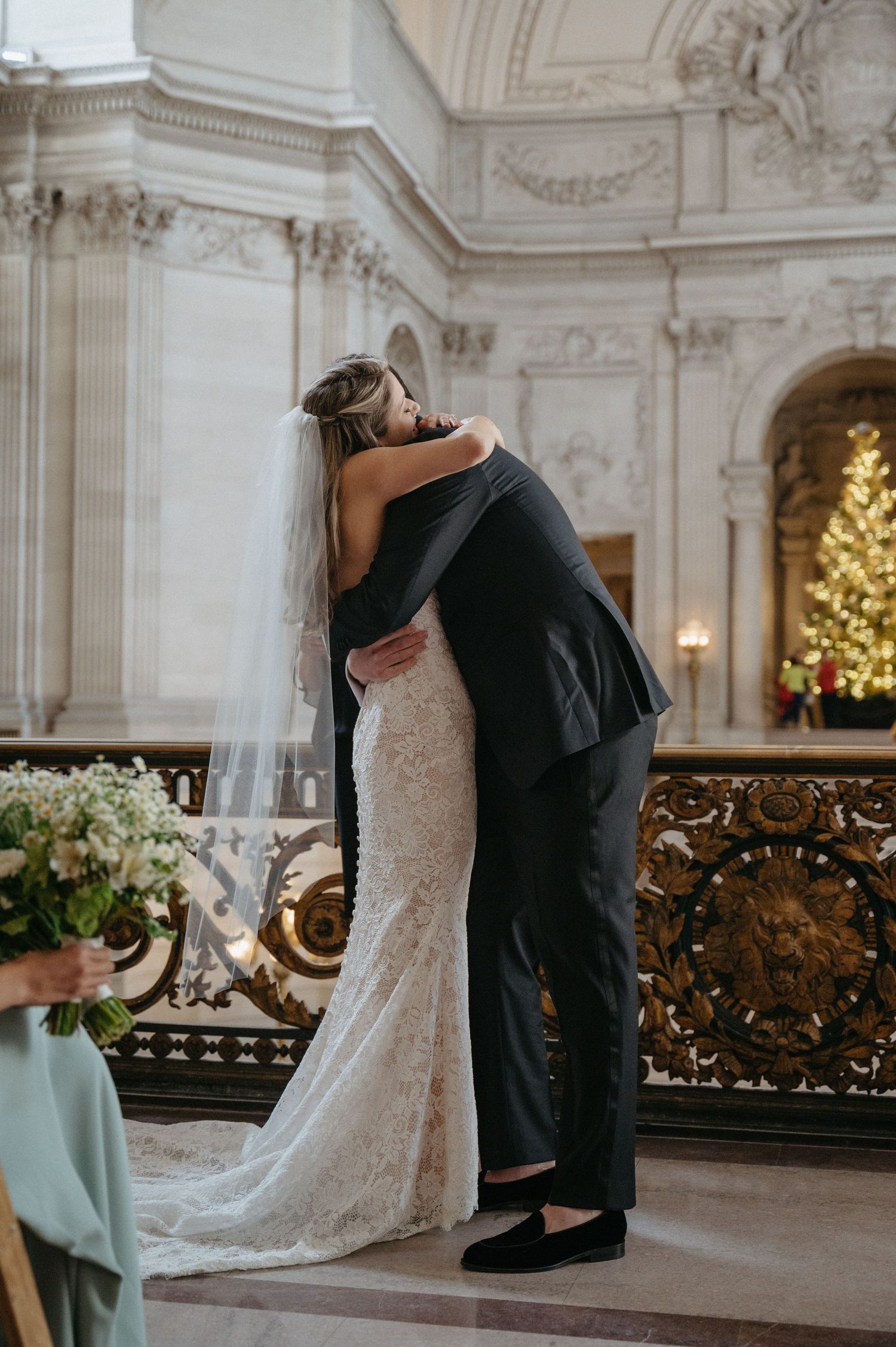 A tender moment captured between a couple during their wedding in an elegant marble hall.