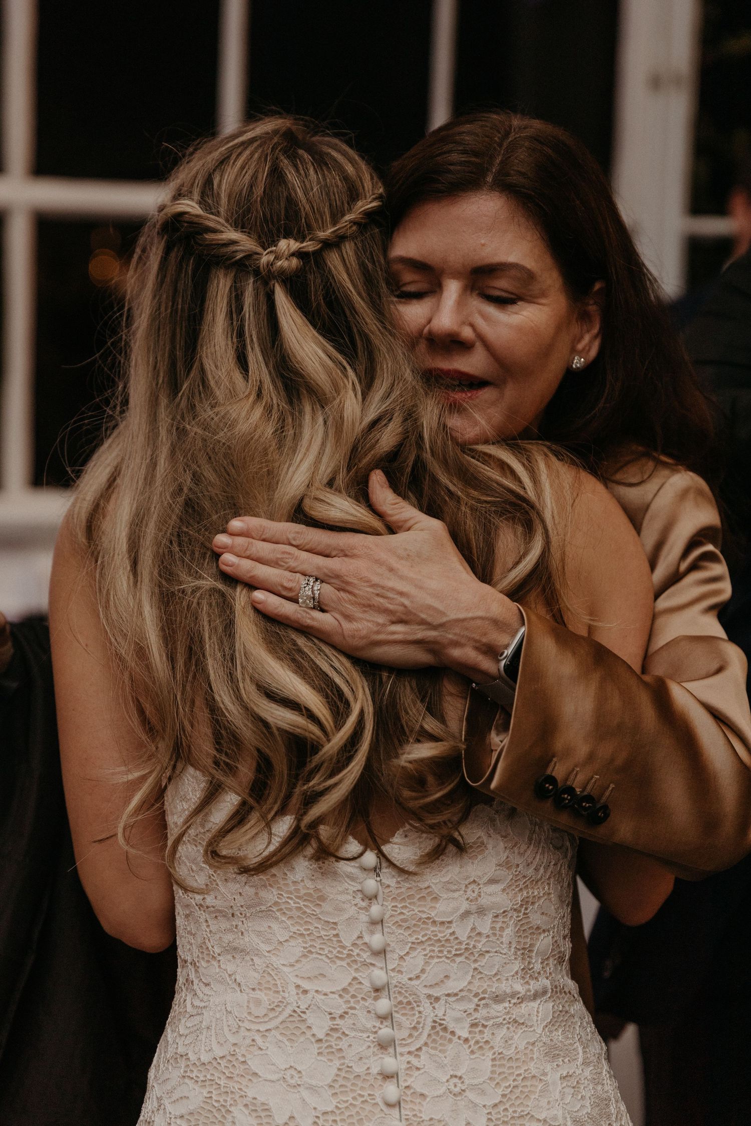 An emotional embrace shows two people sharing a tender moment at a wedding.