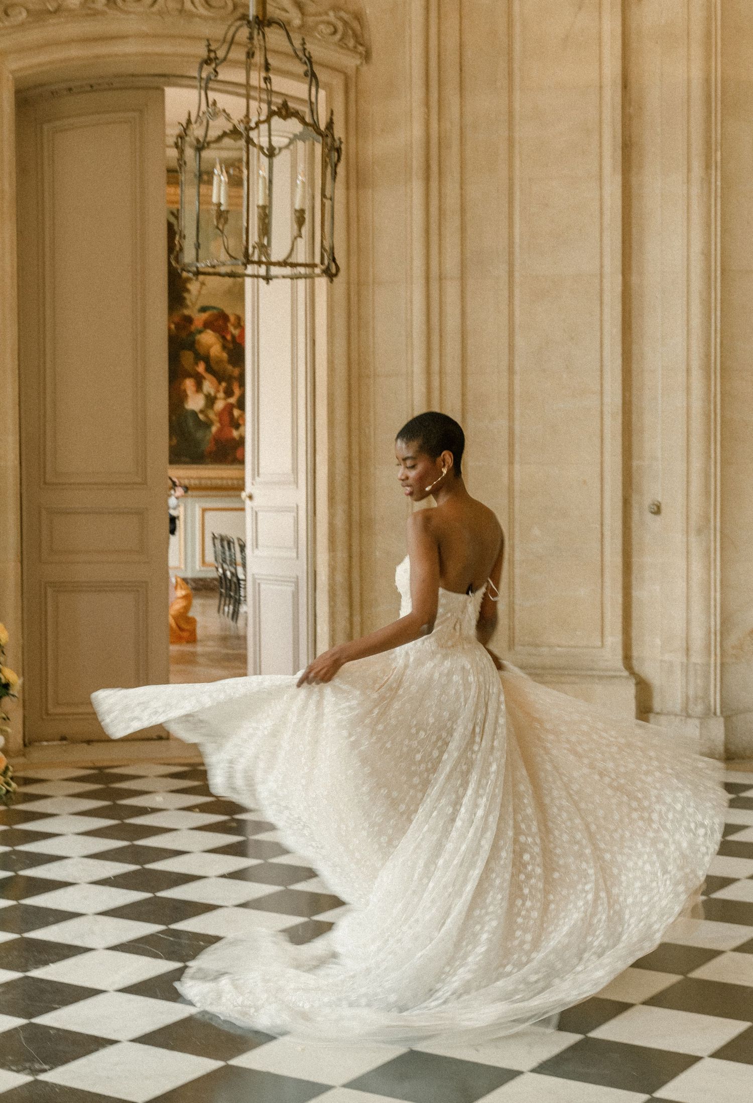 Stunning wedding dress twirl shot on checkerboard floor in classic French interior.