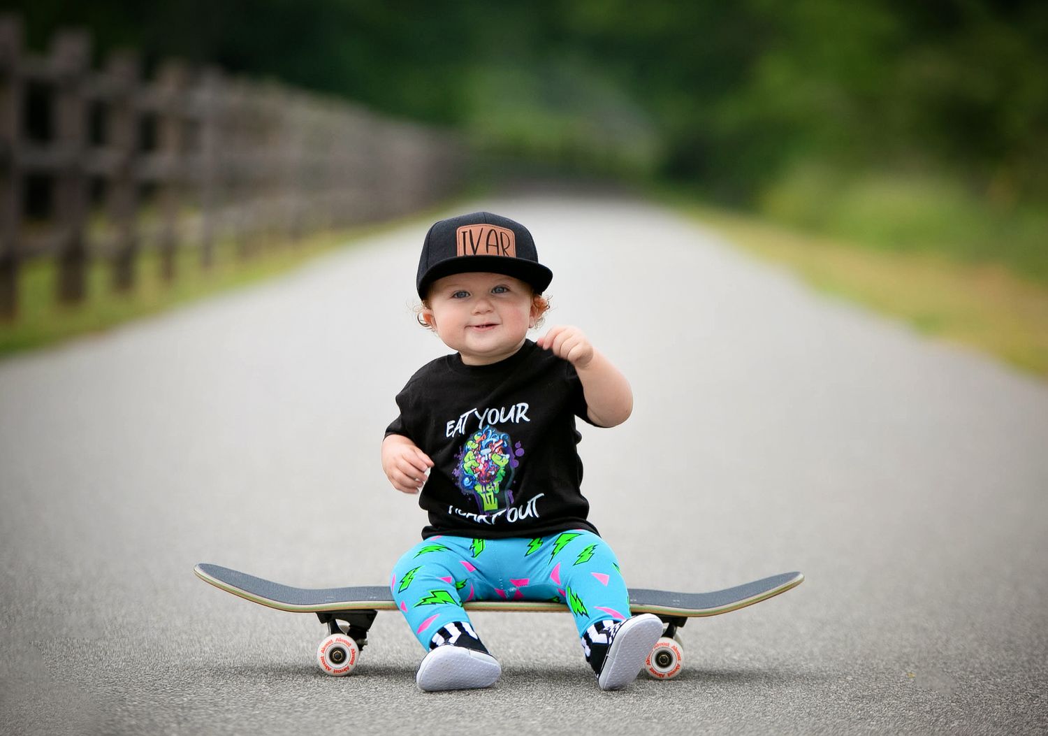 Adorable skater boy one-year milestone session sitting on his skateboard with his skater hat and outfit. - Greenville SC newborn Photograper