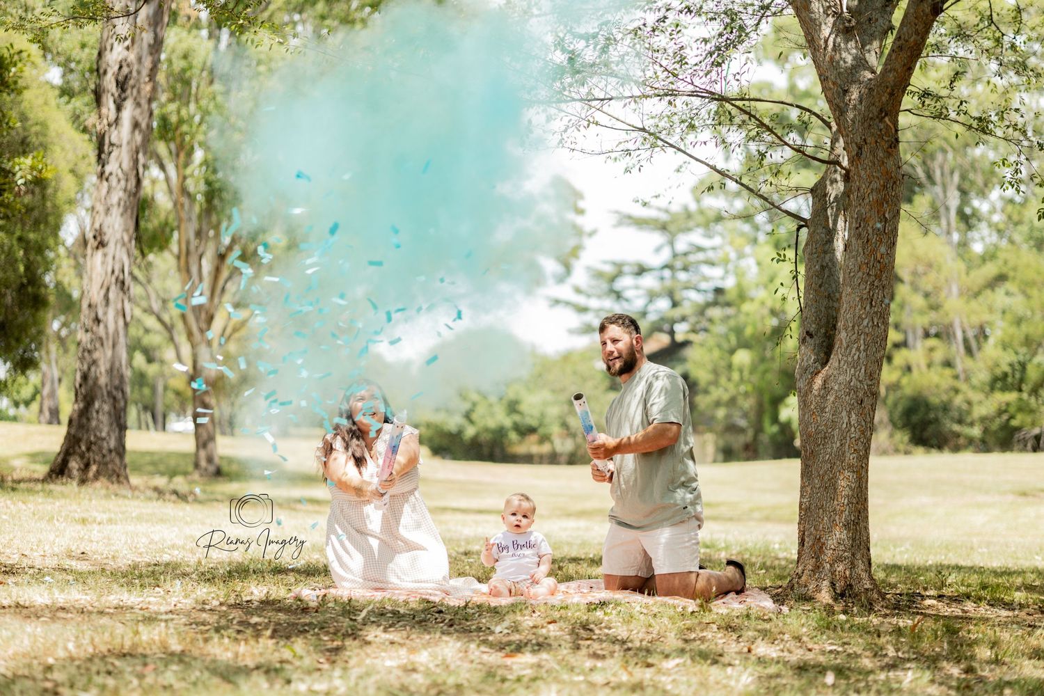 Family gender reveal celebration in a park with colorful confetti powder cannon.