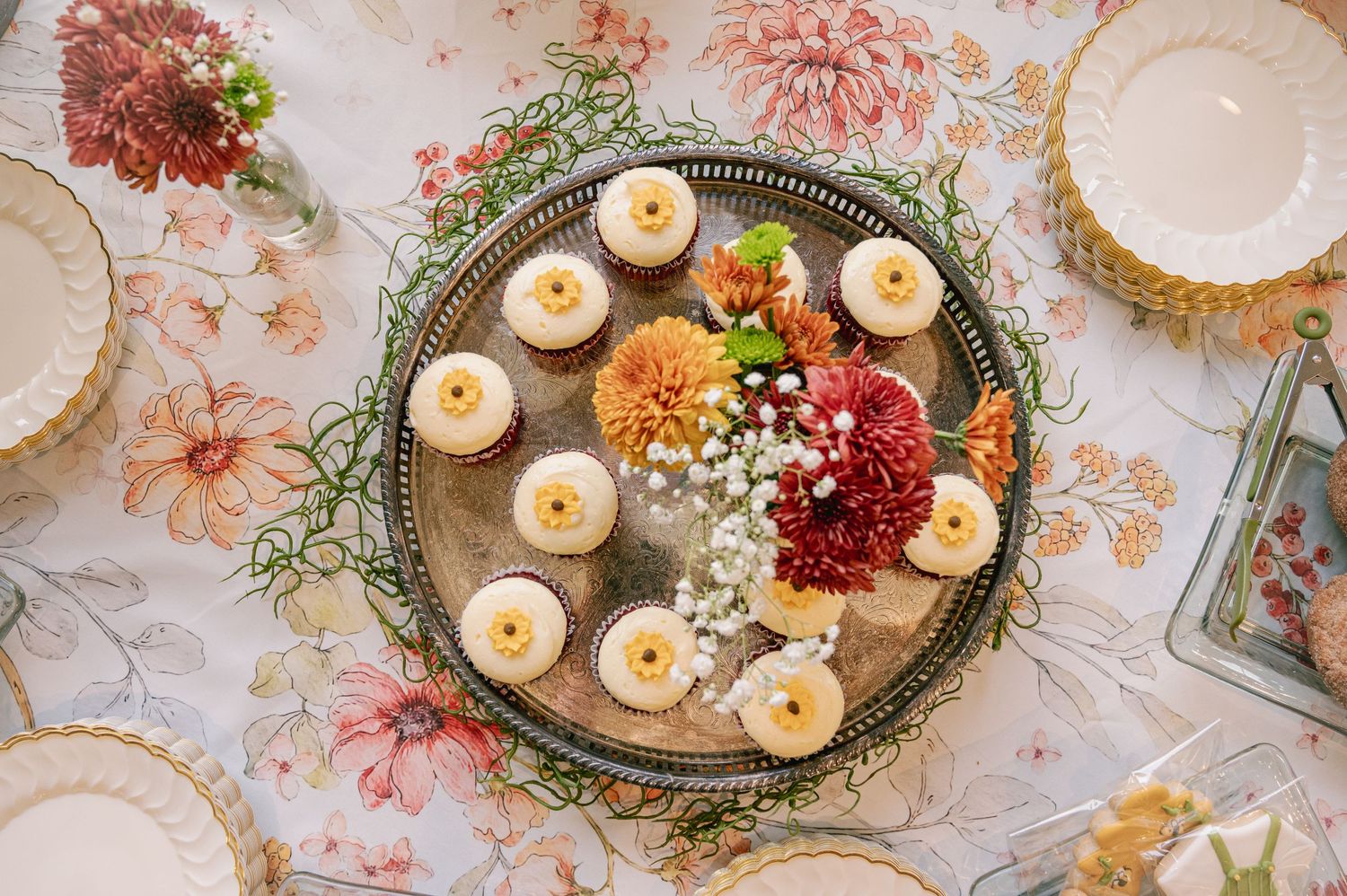 Elegant table setting with lit candles and floral arrangements on vintage tablecloth.