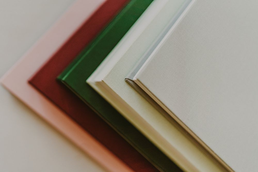 Close-up of layered paper or card stock in pink, red, green, and cream colors.