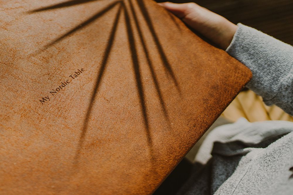 Close-up of a brown leather book cover with sunburst shadow pattern.