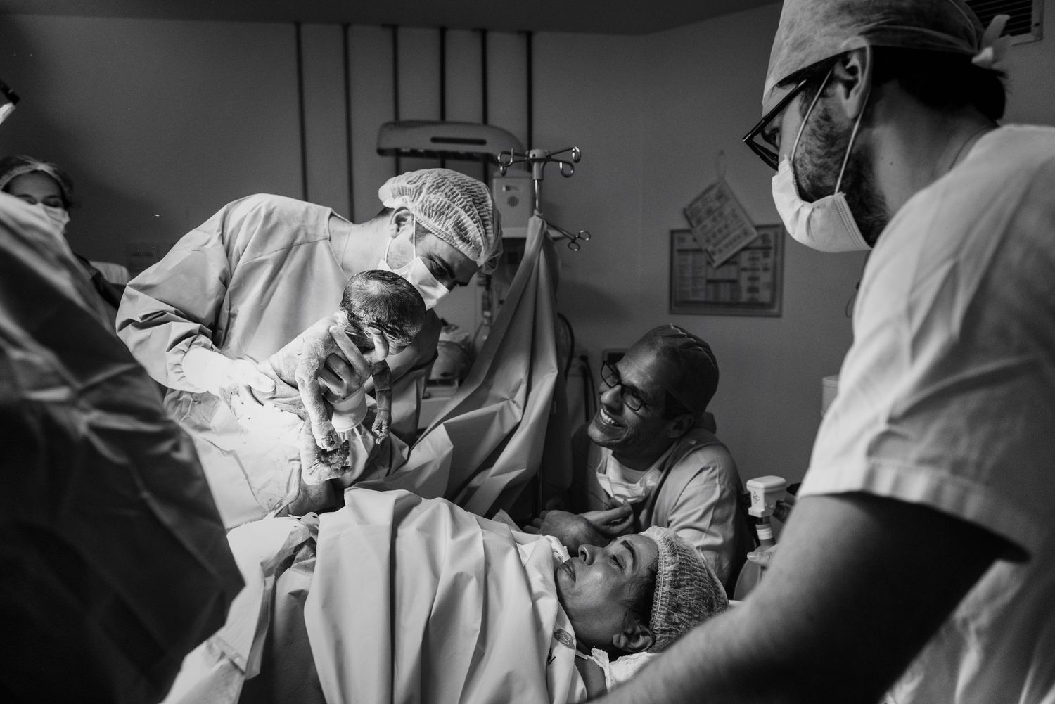 Medical professionals working together during a surgical procedure in black and white.