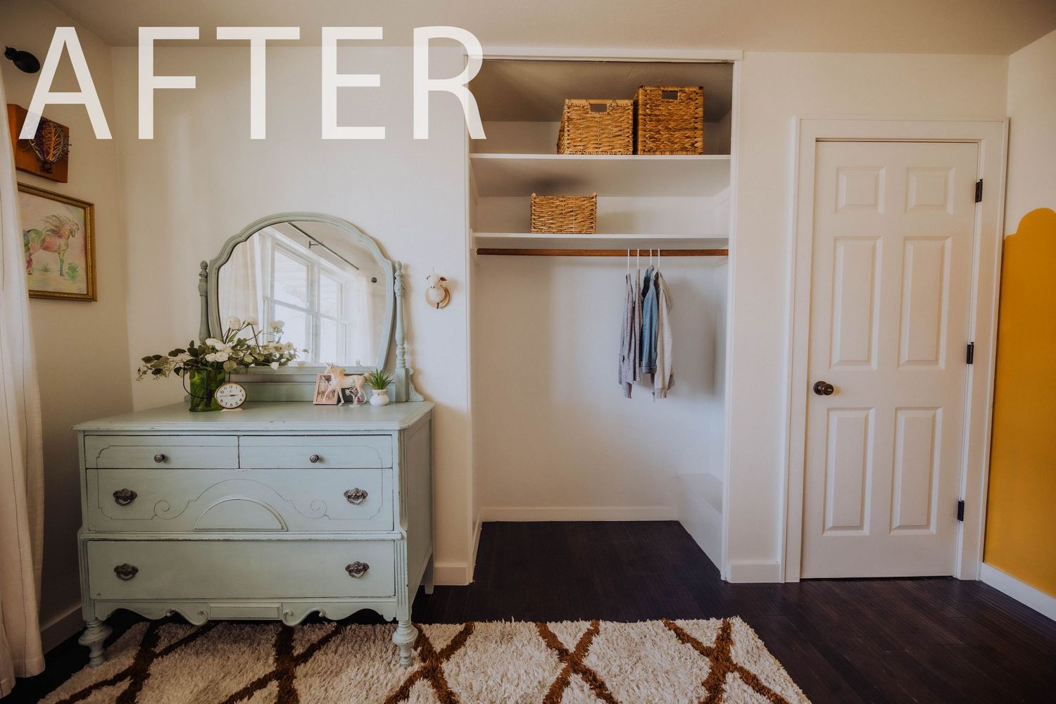 Clean bedroom with geometric rug and orange accent wall showing organized storage solutions.