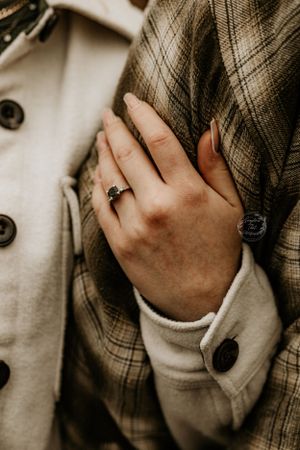 Close-up detail of hands gently touching plaid fabric.
