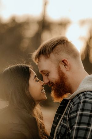 Couple sharing a romantic moment in golden sunlight with soft focus.