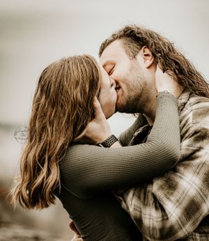 Intimate sepia-toned portrait of a couple in casual attire.