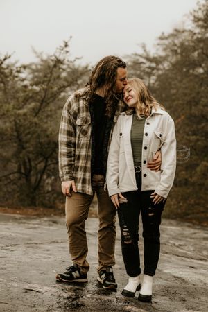 Casual couple in denim and plaid walking together outdoors.