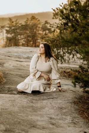 Artistic portrait sequence showing graceful poses on a rocky surface in warm earth tones.