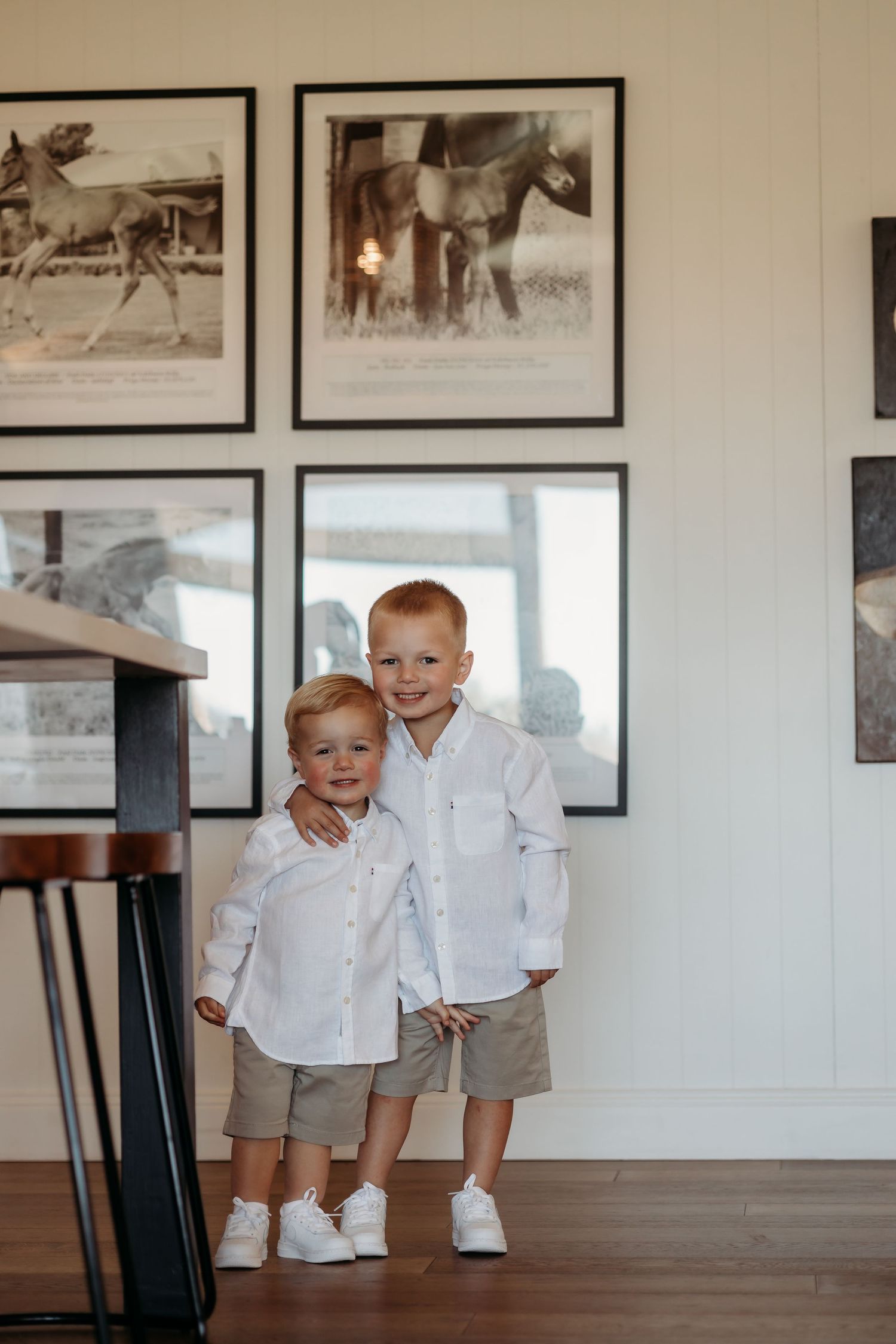 Interior room with hardwood floors and black and white photographs hanging on white walls.
