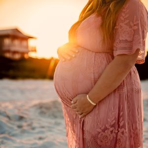 Maternity photo capturing an expecting parent during sunrise, photographed by Sierra Lopez Productions.