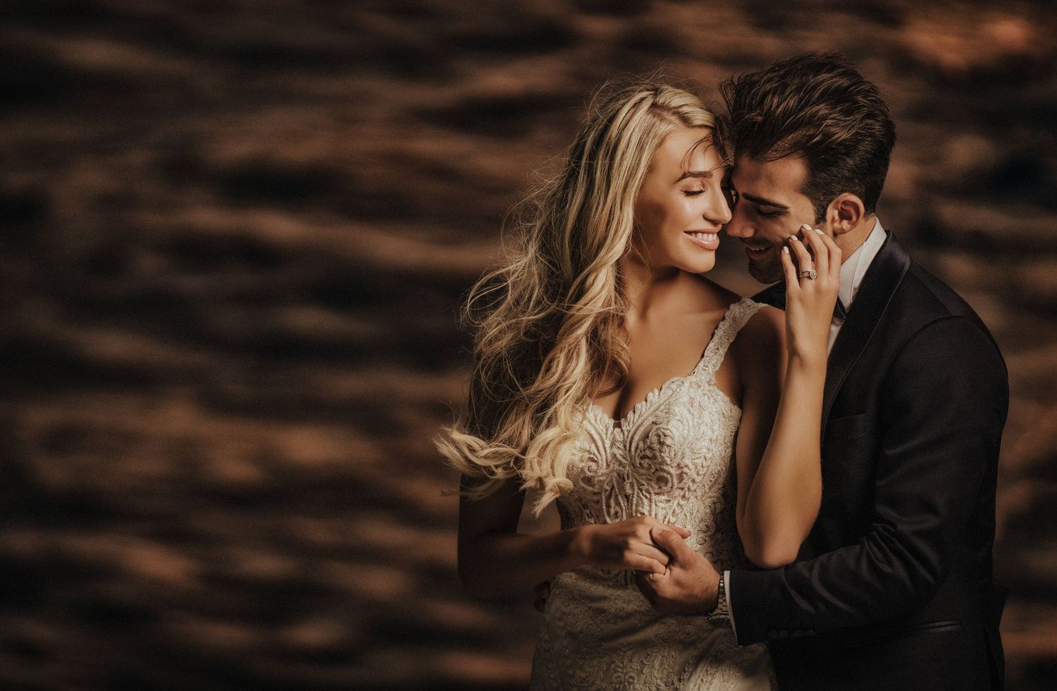 Romantic sunset photoshoot on a beach with warm moody lighting.